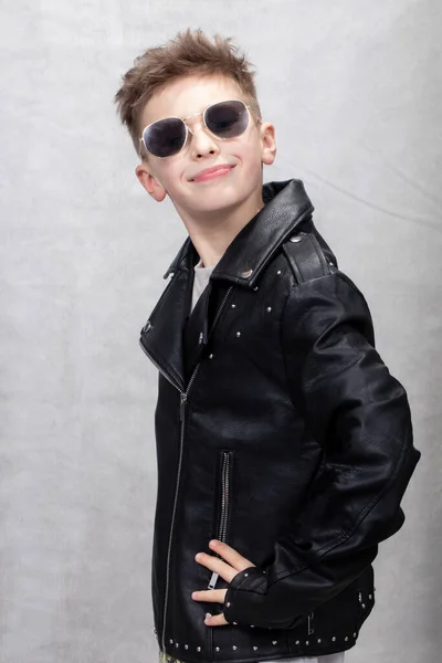 Deri Ceketli Gözlüklü Yakışıklı Çocuk Kameraya Bakıp Gülümsüyor — Stok fotoğraf