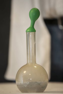 Bilimsel deneyimi göstermek için plastik bir balon kimyasal şişenin üzerine gerilir..