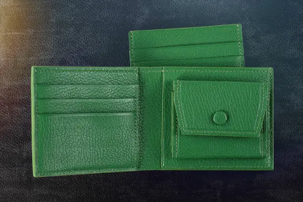 Leather products. Wallet business card holder made of green leather on a black background.