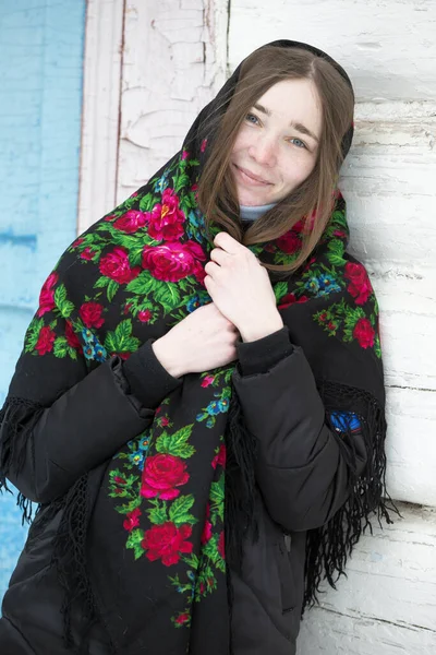 Portrait of a beautiful girl in a Russian headscarf. Young woman . Russian village in winter.