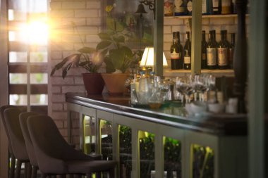 Barda bardakları ve şarap dolabı olan rahat bir restoranın içinde..