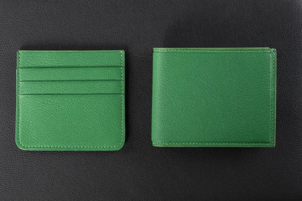Leather products. Wallet business card holder made of green leather on a black background.