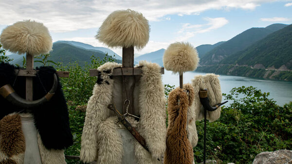 Georgian papakhas are sold to tourists against the backdrop of mountains. Journey along the military Georgian road.