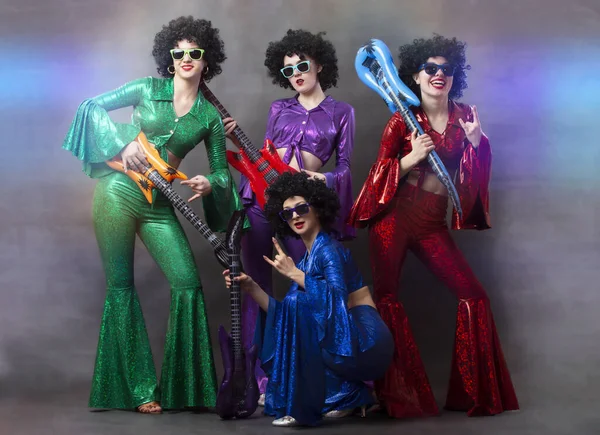 穿着艳丽服装 戴着吉他手的非洲假发的女孩 为妇女而设的老式音乐迪斯科乐队 免版税图库照片