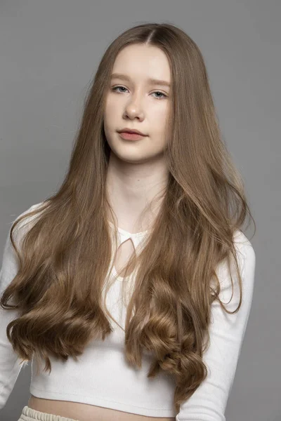 Teenage Dívka Blond Dlouhé Vlasy Šedém Pozadí — Stock fotografie