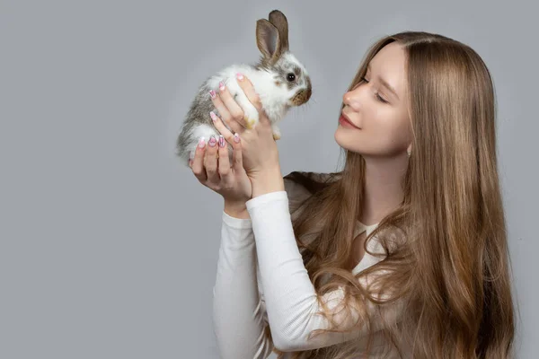 Felice Giovane Ragazza Che Tiene Coniglio Bianco Uno Sfondo Grigio — Foto Stock