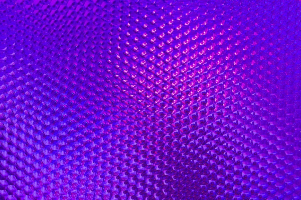 Violet pink geometric background of colored corrugated glass.