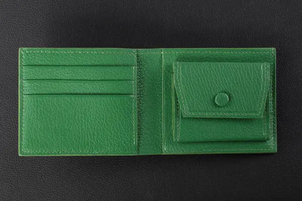 Leather products. Green leather purse on a black background.