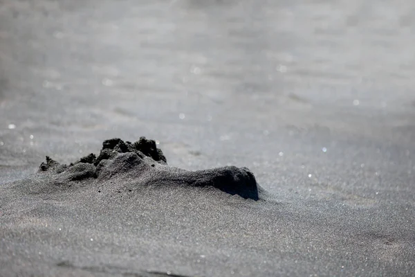 Black magic sand close-up.Sand texture wet