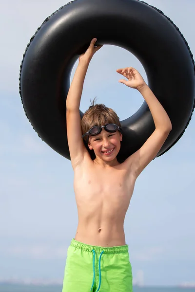 快乐的男孩 戴着泳镜 戴着充气泳圈 图库照片
