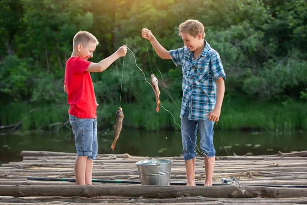 孩子们钓鱼时钓到了一条鱼 并互相展示给对方看 — 图库照片