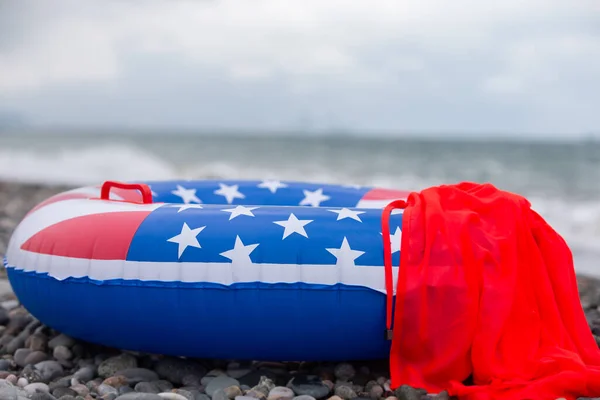 A lifebuoy with an American flag painted on the seashore. Vacation vacation on American beaches.