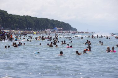 Ağustos 06, 2022. Georgia mı? Ureki köyü. Merkez plaj. Denizde yıkanan bir grup insan..