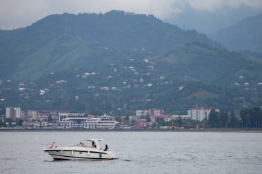 07 Ağustos 2022. Georgia mı? Batum. Gürcistan dağlarının arka planına karşı denizde motorlu tekneler.