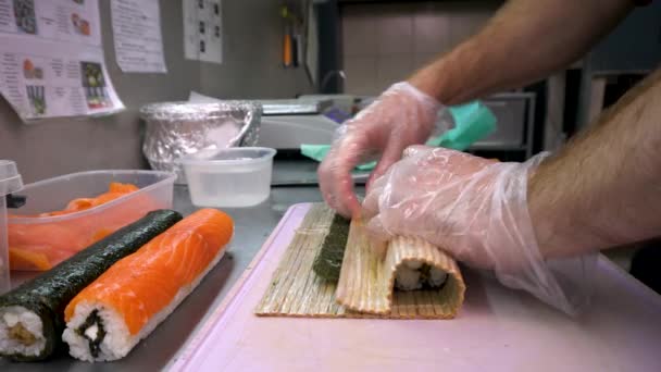 寿司屋のシェフが米や魚介類からロールを準備 — ストック動画