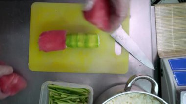 Bir suşi restoranının şefi pirinç ve deniz ürünleri ruloları hazırlar..