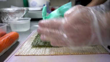 Bir suşi restoranının şefi pirinç ve deniz ürünleri ruloları hazırlar..