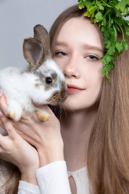 Kafasında bir demet maydanoz ve bir tavşanla kırsal bir kızın portresi..