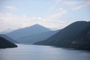 Arkasında dağlar olan mavi bir göl. Dağ manzarası.