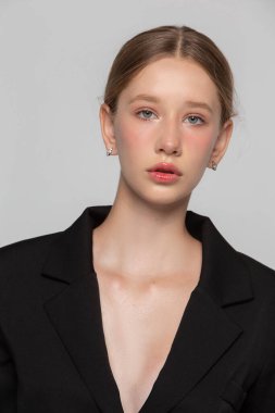 Gri arka planda mavi gözlü sarışın bir kızın portresi. On yedi yaşında bir kız..