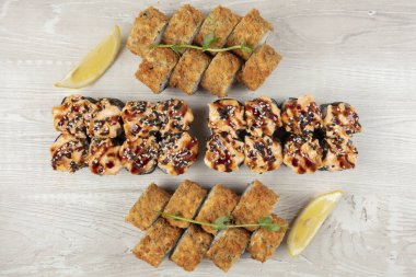 Beyaz ahşap bir arka planda çeşitli suşi ruloları. Japon yemeği..