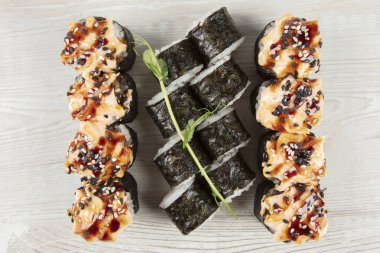 Beyaz ahşap bir arka planda çeşitli suşi ruloları. Japon yemeği..