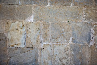 Dağlık bölgenin gözenekli taşlarından yapılmış arka plan eski duvarı. Eski bir kilisenin duvarı.