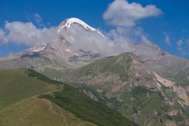 Kafkasya, Georgia 'daki Kazbeg Dağı manzarası. Karlı zirvenin ve Gergeti buzulunun altında, yamaçlar ıssız ve kayalık. Sakin ol. Doğal bir ilaç. Buzulun büyük ayağı.
