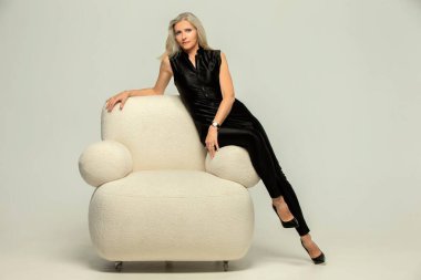 Kolay bir sandalyede poz veren narin, yaşlı, güzel bir kadın. Çok güzel yaşlanıyor. 50 yıldır..