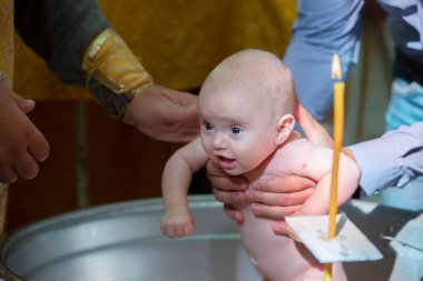 Bir bebeğin ortodoks vaftiz töreni. Bir bebeği kilisenin yazı tipinde yıkamak inançlı olmak demektir..