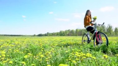 Sarışın genç bir kız karahindiba tarlasının ortasında bisiklette oturuyor. Bir buket tutuyor ve kokusunu alıyor. Baharı ve doğayı seviyor..