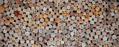 Ahşap yuvarlak kütüklerin arka planı düzgünce katlanmış.