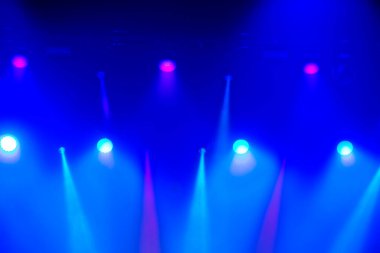 Lazer ışıklarından gelen beyaz ışık huzmeleri ile mavi sahne ışıklandırması.