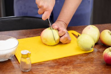Elmaları bıçakla kesen eller. Meyvelerden sağlıklı yiyecekler hazırlayın..