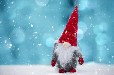 Bir Noel kartı. Kış arkaplanındaki kırmızı şapkalı şirin cüce..