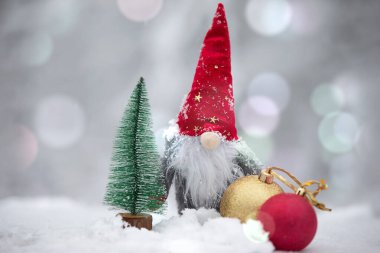 Bir Noel kartı. Kış arkaplanındaki kırmızı şapkalı şirin cüce..