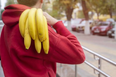 Bir kadın arkasında muz dalı tutuyor..