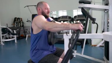 Spor salonunda bir adam çalışıyor. Sporcu bir sporcu sırt kaslarını çalıştırıyor..