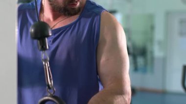 Spor salonunda bir adam çalışıyor. Pazılarını şişiriyor..