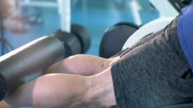 Kas geliştirme makinesinde damarları olan tanınmayan bir sporcunun bacakları..