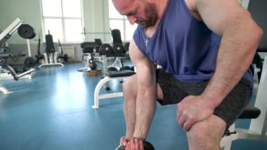 Erkek sporcu spor salonunda kettlebell ile güç egzersizleri yapıyor..