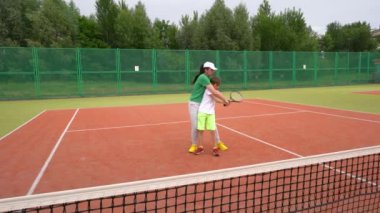 Tenis kortunda, genç çocuklar antrenmanlarına tenis antrenmanlarıyla başlarlar..