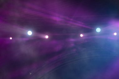 Sahne lambaları ile soyut mor dumanlı arkaplan.