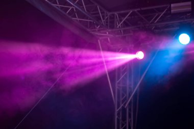 Mor bir arka planda sahne ışığından beyaz dumanlı bir ışık demeti. Sahne tasarımının bir parçası.