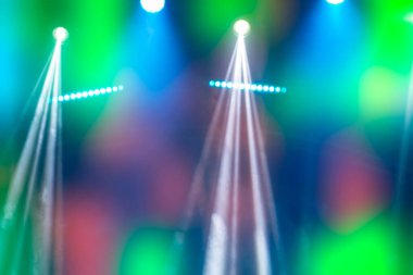 Sahne ışıklarından gelen beyaz ışık demetleriyle soyut çok renkli disko arkaplanı.