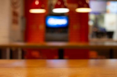 Mutfak ve barın arka planında ahşap gövde ve kırmızı lambalar var..