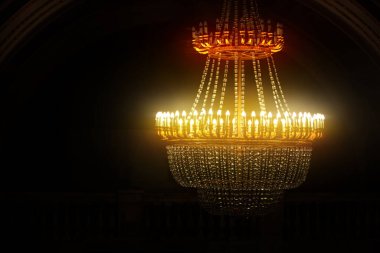 Kristal kolyeli ve sarı parıltılı klasik büyük avize..