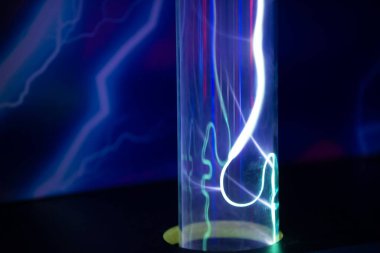 Üzerinde kırmızı bir çizgi olan mor ve mavi bir tüp. Tüpün ışığı yanıyor ve o bir neon ışığı.