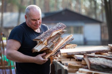 Yaşlı bir adam kış için yakacak odun hazırlar..