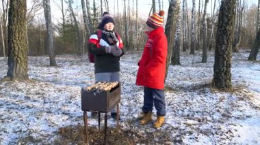 Arkadaşlar karlı bir ormanda barbekü yapıyor..